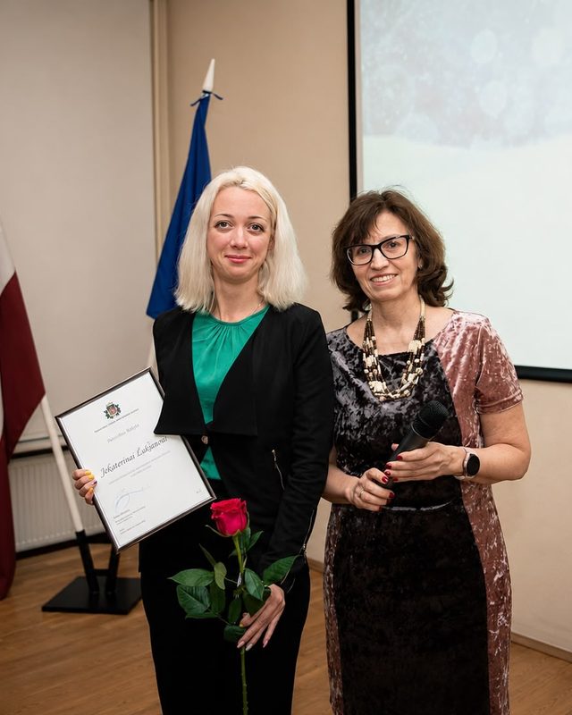 Jekaterina saņem Patērētāju tiesību aizsardzības centra atzinību Latvijas un ES karogu priekšā