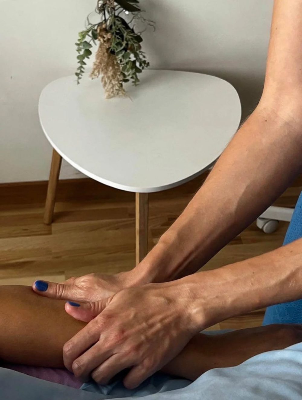 Rokas pleca rituāla laikā; blakus galdiņš ar kaltētiem ziediem